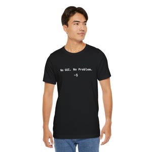 Puede incluir: Camiseta negra con el texto blanco "No GUI. No Problem." junto con un símbolo de tilde y dólar. La camiseta es de cuello redondo.