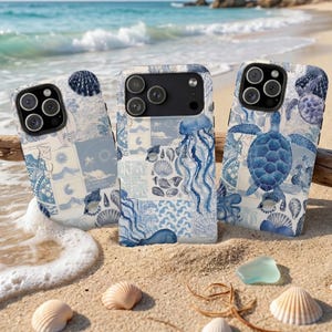 May include: Three phone cases with blue and white ocean-themed designs. The cases feature images of seashells, jellyfish, and sea turtles. The cases are on a sandy beach with seashells and ocean waves in the background.