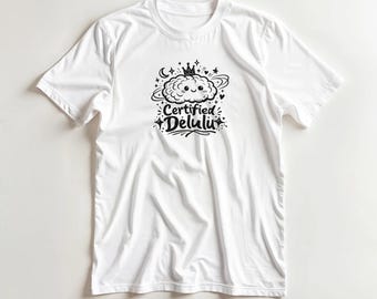May include: White t-shirt with a black graphic of a smiling cloud wearing a crown, surrounded by stars and a crescent moon. The text "Certified Delulu" is below the cloud design.