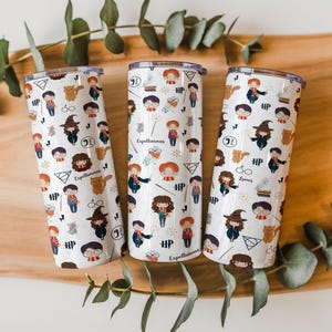 May include: Three white cylindrical tumblers with lids, each featuring a repeating pattern of cartoon characters, wands, owls, cats, glasses, and the text "Expelliarmus" and "HP" in black, brown, orange, and yellow colors across the exterior surface.