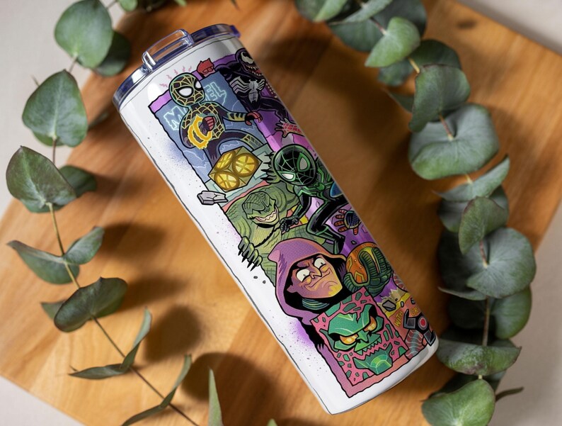 May include: A white stainless steel tumbler featuring a comic book-style illustration of Spider-Man and other Marvel characters. The design includes vibrant colours and the word "Marvel". The tumbler has a silver lid.