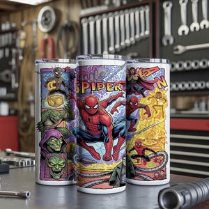 May include: Three cylindrical tumblers featuring a colorful comic book graphic print. The design displays various characters including Spider-Man, Green Goblin, and Doctor Strange, with the text SPIDER-MAN prominently featured in yellow block letters.
