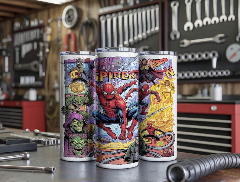 May include: Three cylindrical tumblers featuring a colorful comic book graphic print. The design displays various characters including Spider-Man, Green Goblin, and Doctor Strange, with the text SPIDER-MAN prominently featured in yellow block letters.