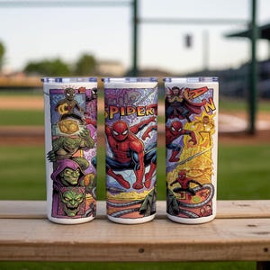 May include: Three cylindrical tumblers with lids featuring a colorful comic book style graphic print. The design displays various characters including Spider-Man, Doctor Strange, and Green Goblin, with the text SPIDER-MAN visible on the surface.