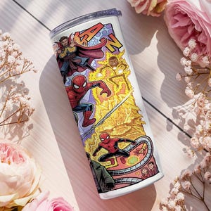 May include: A white cylindrical tumbler featuring a colorful comic book style graphic print of various superheroes including Spider-Man and Doctor Strange, with yellow lightning effects and a clear plastic lid on top of the beverage container.