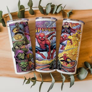 May include: Three cylindrical tumblers featuring a colorful comic book style graphic print of Spider-Man and various villains. The designs include illustrations of Spider-Man, Green Goblin, Doctor Strange, and other characters with the text SPIDER.