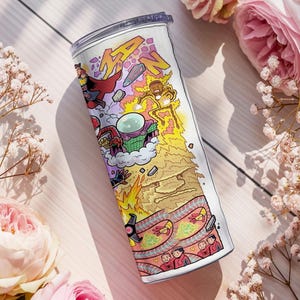 May include: A stainless steel travel mug with a vibrant comic book-style design. The illustration includes the word "MAN" in yellow, plus superhero characters and action scenes. The mug is set against a backdrop of pink roses and delicate white flowers.