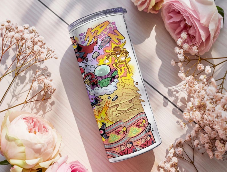 May include: A stainless steel travel mug with a vibrant comic book-style design. The illustration includes the word "MAN" in yellow, plus superhero characters and action scenes. The mug is set against a backdrop of pink roses and delicate white flowers.
