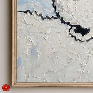 K&ouml;nnte beinhalten: Abstraktes &Ouml;lgem&auml;lde mit dicken wei&szlig;en Pinselstrichen, akzentuiert durch schwarze und hellblaue Bereiche. Das Kunstwerk ist in einem hellen Holzrahmen gerahmt, wodurch ein strukturierter und geschichteter Effekt entsteht. Das Gem&auml;lde erzeugt Tiefe und Bewegung.