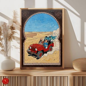 May include: A framed painting depicts a red jeep driving through a desert landscape under a blue sky. The artwork features a group of people in the jeep, with a decorative archway framing the scene. The painting is displayed on a wooden surface.