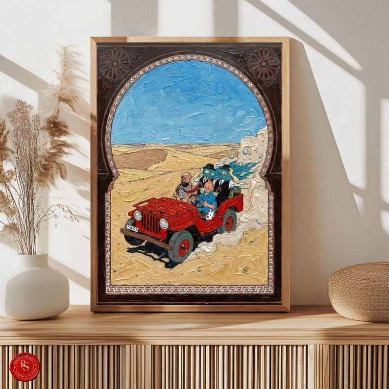May include: A framed painting depicts a red jeep driving through a desert landscape under a blue sky. The artwork features a group of people in the jeep, with a decorative archway framing the scene. The painting is displayed on a wooden surface.