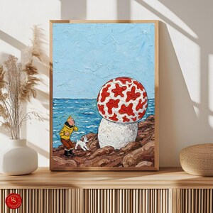 Puede incluir: Una pintura enmarcada que presenta un personaje de dibujos animados con un abrigo amarillo y un perro blanco en una orilla rocosa, con un gran objeto en forma de hongo rojo y blanco. El fondo muestra un oc&eacute;ano y un cielo azules.