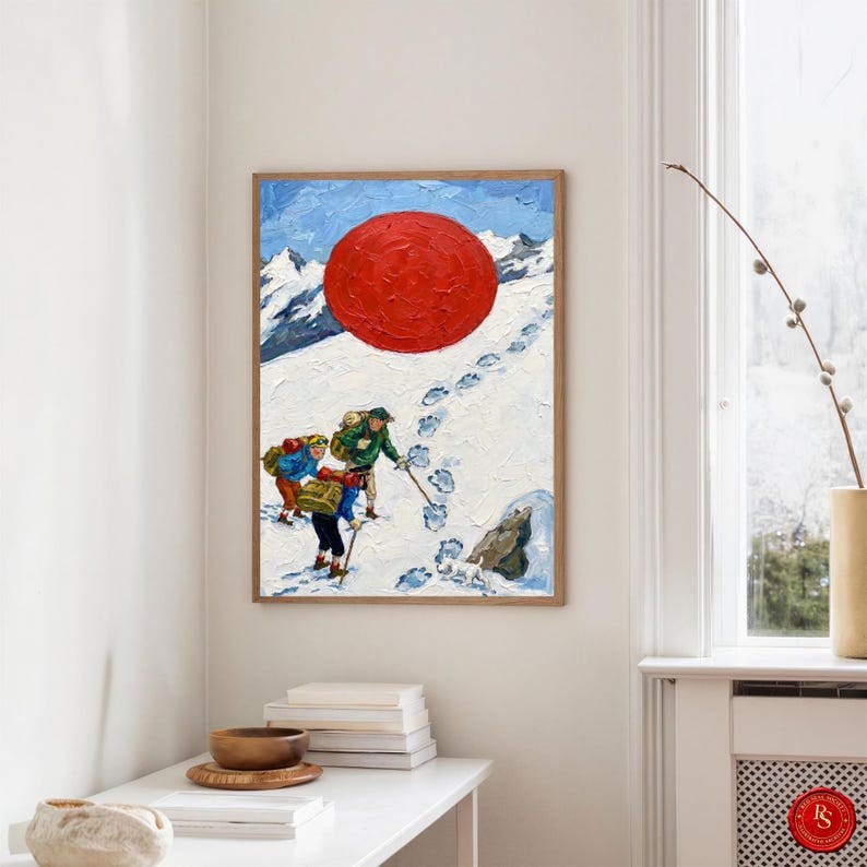 May include: A framed painting depicts three figures climbing a snowy mountain, with a large red sun in the sky. The artwork features a wooden frame and a textured, impasto style, with visible brushstrokes. The climbers are wearing colorful clothing and carrying backpacks.