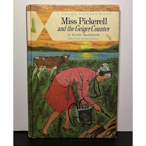 Puede incluir: Portada de libro vintage titulada "Miss Pickerell and the Geiger Counter" de Ellen MacGregor. La ilustración muestra a una mujer usando un contador Geiger en un campo con una vaca. La portada tiene un fondo de puesta de sol.