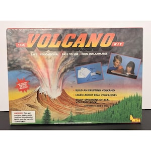 May include: The Volcano Kit box features a volcano erupting with red and white smoke. The box includes text that says "Safe, Educational, Easy to Use, Non-Inflammable". It also says "Build an erupting volcano" and "Learn about real volcanoes".