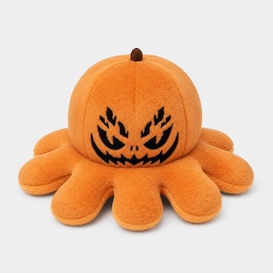 May include: A plush orange octopus toy with a rounded pumpkin-shaped head and a small brown stem on top. The front of the head features a black embroidered design of a jagged, spooky face with sharp eyes and a wide, toothy grin.