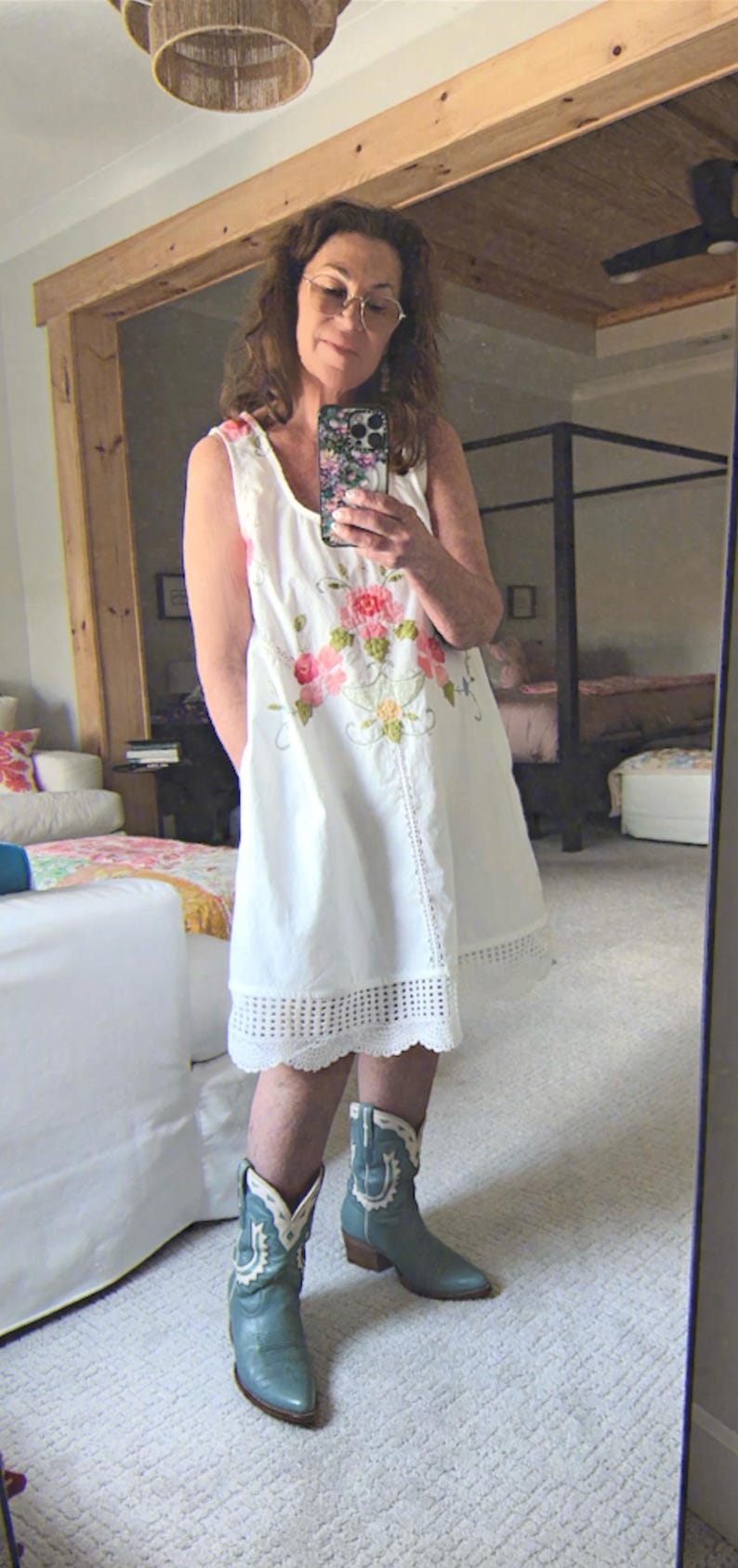 May include: White sleeveless dress with floral embroidery and a scalloped hem. The dress is paired with turquoise cowboy boots.