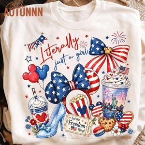 May include: White sweatshirt with a patriotic design featuring a bow, Mickey Mouse ears, and a high heel. The design includes the text "Literally just a girl" and various American flag-themed elements, such as stars, stripes, and fireworks.