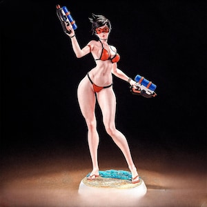 May include: A figurine of a character in a red and black bikini, holding two water guns. The figure has short black hair, red goggles, and is standing on a small base with a beach scene.