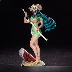Op de afbeelding: Gedetailleerd beeldje van een vrouwelijk anime-personage met lang, blauwgroen haar, gekleed in een groene outfit en een schedel-gehoornde hoofdtooi. Ze houdt een zwaard vast en staat op een zanderige basis met een rood en wit object. De figuur poseert tegen een donkere achtergrond.