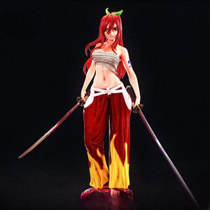 May include: A figurine of a female anime character with long red hair, wearing a white top, red pants with yellow flames, and holding two swords. The figure has a determined expression and a tattoo on her arm.