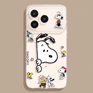May include: Transparent phone case decorated with Snoopy and other Peanuts characters. The case has a pale pink backdrop with several Snoopy illustrations, including Snoopy with sunglasses and Snoopy peeking out. The word "Snoopy" is printed on the case.