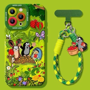 May include: A green phone case featuring a cartoon illustration of a mole, rabbit, and other characters in a forest scene. The case has a matching green strap with a mole charm holding strawberries. The case has the words "GOOD LUCK".
