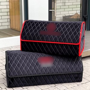 May include: Two black car trunk organizers with a diamond pattern. The top organizer has a red trim. The organizers are made of a soft material and are designed to keep the car trunk organized.