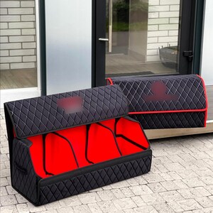 May include: Two black quilted car organizers with red interiors. The organizers have a diamond pattern and are designed to store items in a vehicle. One organizer is open, revealing the red interior.