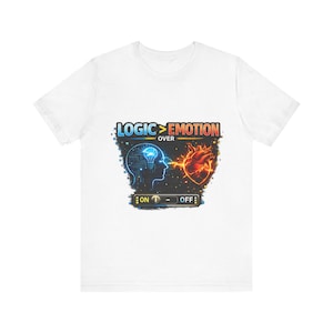 Op de afbeelding: Wit T-shirt met een grafisch ontwerp met een hersen en een hart verbonden door een vonk. De tekst "LOGIC > EMOTION" staat boven de afbeeldingen, met een "ON - OFF" schakelaar eronder. Het ontwerp gebruikt blauw, oranje en geel.