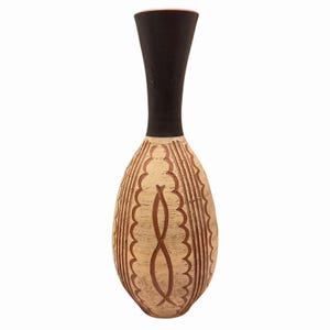 May include: A tall vase with a slender, matte black neck and a rounded, bulbous body. The body features a light beige, textured surface decorated with carved, dark brown vertical patterns consisting of scalloped lines and central loops.