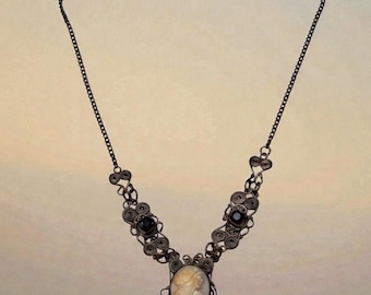 Set antico in argento 800 con collana e bracciale in filigrana a conchiglia e cammeo, con pietre di vetro viola.