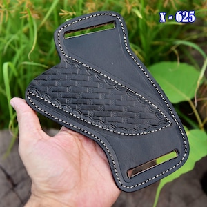 May include: Black leather knife sheath with a basketweave pattern and white stitching. The sheath has a rectangular opening at the top and a metal accent at the bottom. The text "X - 625" is visible in the upper right corner.