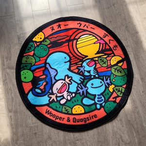 May include: Circular rug with a vibrant design of cartoon characters, the text "Wooper & Quagsire", and Japanese characters. The artwork includes a sunset and plants, set against a black border.