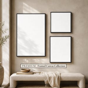 Peut inclure: Trois toiles blanches vierges dans des cadres noirs fins disposées sur un mur. La collection comprend un grand rectangle vertical, un rectangle vertical moyen et une toile carrée. Le texte PREMIUM Framed Canvas Collection est visible.