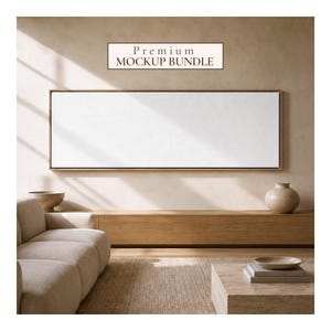 Könnte beinhalten: Eine große, horizontale, rechteckige leere Leinwand in einem dünnen Holzrahmen, die an einer Wand montiert ist. Über der Leinwand zeigt ein rechteckiges Schild den Text Premium MOCKUP BUNDLE. Die Szene umfasst ein beiges Sofa, eine Holzkonsole und eine Vase.