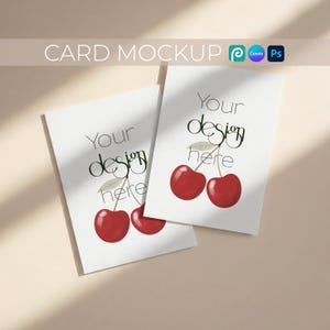Könnte beinhalten: Zwei weiße Karten mit Kirschdesign und dem Text "Your design here". Die Karten liegen auf einer beigen Oberfläche. Die Worte "CARD MOCKUP" stehen oben.