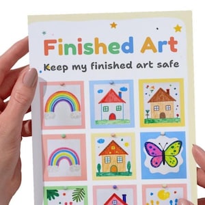 May include: A rectangular white sign with the text Finished Art and Keep my finished art safe. The sign features a grid of nine colorful illustrations including rainbows, houses, a butterfly, and handprints, each framed in pastel borders.