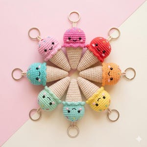 Puede incluir: Una colección de ocho llaveros de cono de helado de ganchillo dispuestos en círculo. Cada llavero presenta un helado de diferente color, incluyendo rosa, rojo, naranja, amarillo, verde y azul, con una cara sonriente y chispas. Los conos son beige.