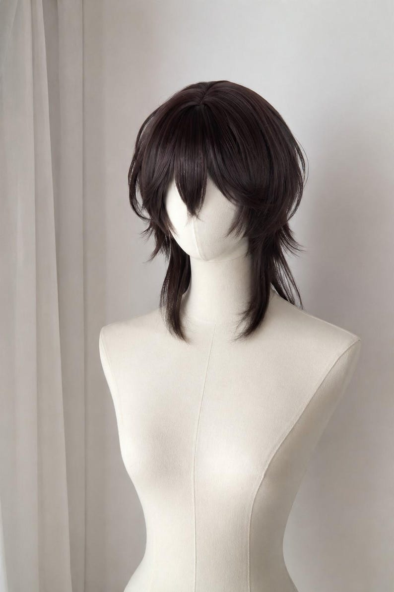 May include: A dark brown wig with a layered, shaggy cut featuring face-framing bangs and longer, textured strands at the back. The hair is styled with a voluminous crown and tapered ends, displayed on a smooth, off-white mannequin head and neck.