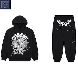 May include: Black hoodie and sweatpants set. The hoodie features a white spider web design and the word "sp5der". The sweatpants have the word "sp5der" on the back and white splatter details. The set is made of a soft material.