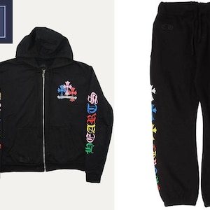 Könnte beinhalten: Ein schwarzer Kapuzenpullover mit Reißverschluss und eine passende Jogginghose mit bunten Kreuzgrafiken auf der Brust und den Beinen. Die Ärmel des Kapuzenpullovers zeigen den Schriftzug CHROME HEARTS in leuchtenden, mehrfarbigen Buchstaben.