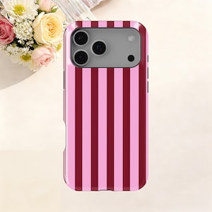 Puede incluir: Una funda para teléfono con rayas rosas y burdeos. La funda tiene un acabado brillante y un recorte para la cámara. La funda está diseñada para adaptarse a un teléfono inteligente y protegerlo de arañazos y daños. Es un accesorio elegante.