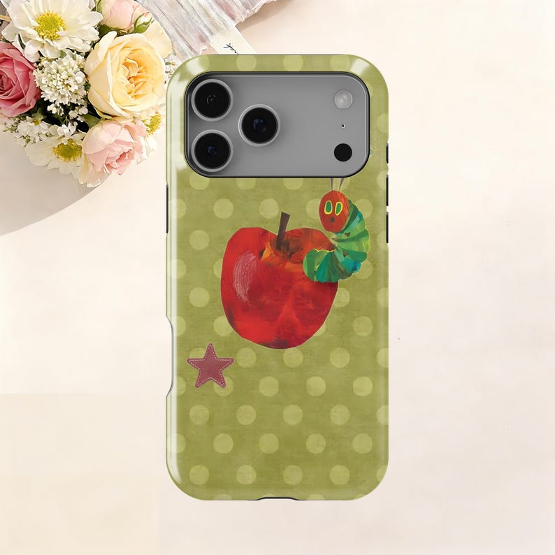 Puede incluir: Funda de tel&eacute;fono con un estampado de lunares verdes. La funda presenta una manzana roja con una oruga verde y una estrella rosa. La funda est&aacute; dise&ntilde;ada para un tel&eacute;fono inteligente.