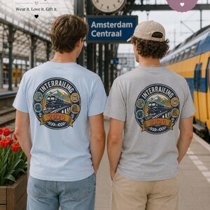 May include: A light blue t-shirt and a grey t-shirt, each featuring a circular graphic on the back. The design includes a train, mountains, and the text "INTERRAILING 2026" surrounded by small icons of a map, passport, coffee cup, and camera.