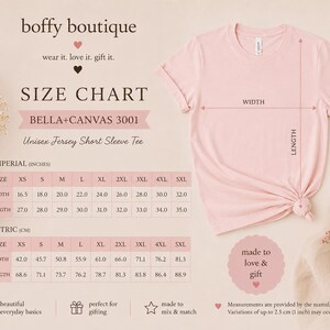 May include: A light pink Unisex Jersey Short Sleeve Tee from Boffy Boutique. The image includes a size chart with measurements in inches and centimeters. The shirt is displayed with measurements for width and length.