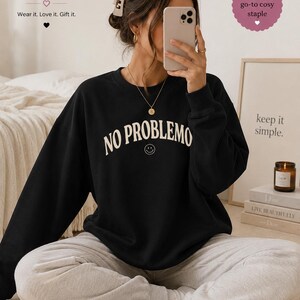 May include: Black crewneck sweatshirt with the text "NO PROBLEMO" in white, featuring a smiley face. The sweatshirt is from Boffy Boutique. The image also includes the text "Wear it. Love it. Gift it."