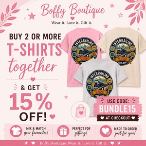May include: Three short-sleeved t-shirts in pink, beige, and light gray. Each shirt features a circular graphic on the back depicting a train on tracks, mountains, and the text INTERRAILING 2026. The image includes text Boffy Boutique, BUY 2 OR MORE T-SHIRTS together & GET 15% OFF, and USE CODE: BUNDLE15.