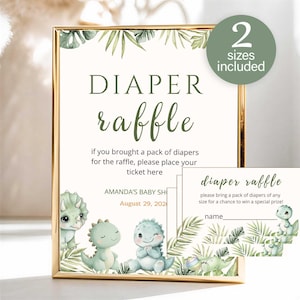 May include: A gold-framed sign and matching cards for a nappy raffle featuring watercolour illustrations of green dinosaurs and tropical leaves. The sign reads DIAPER raffle, if you brought a pack of nappies for the raffle, please place your ticket here.