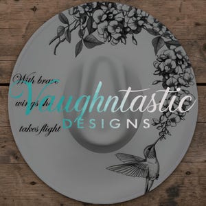 May include: A white ceramic mug with a black handle and the text "But First, Coffee" in a black, handwritten-style font. The mug is on a white surface.